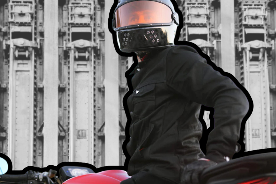 Man wearing PPE on motorcycle with industrial background