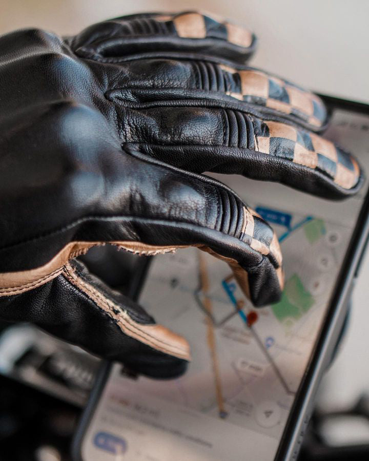 Close-up of Nineone Moto Checkmate Gloves, black and tan leather with checkerboard forefingers, reinforced with Kevlar in impact zones and touch screen-compatible pointer finger