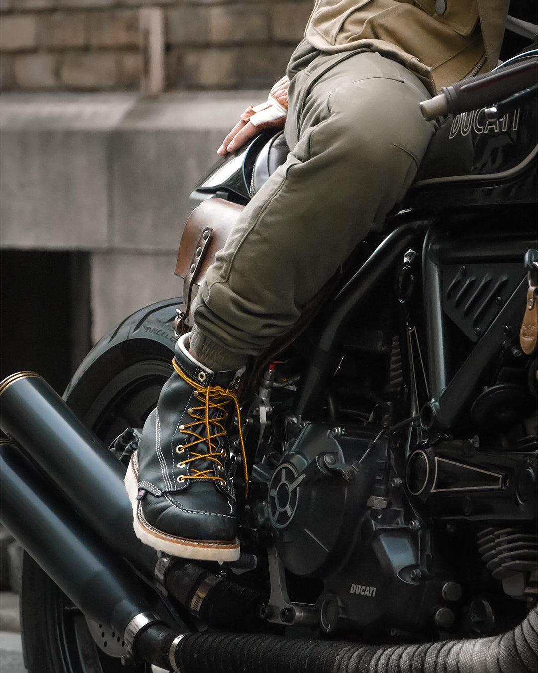 Motorcyclist wearing black Thorogood 6" Moc Toe work boots, showcasing the breathable cotton drill vamp lining, stitched pull-tab, and removable Ultimate Shock Absorption insert for enhanced comfort