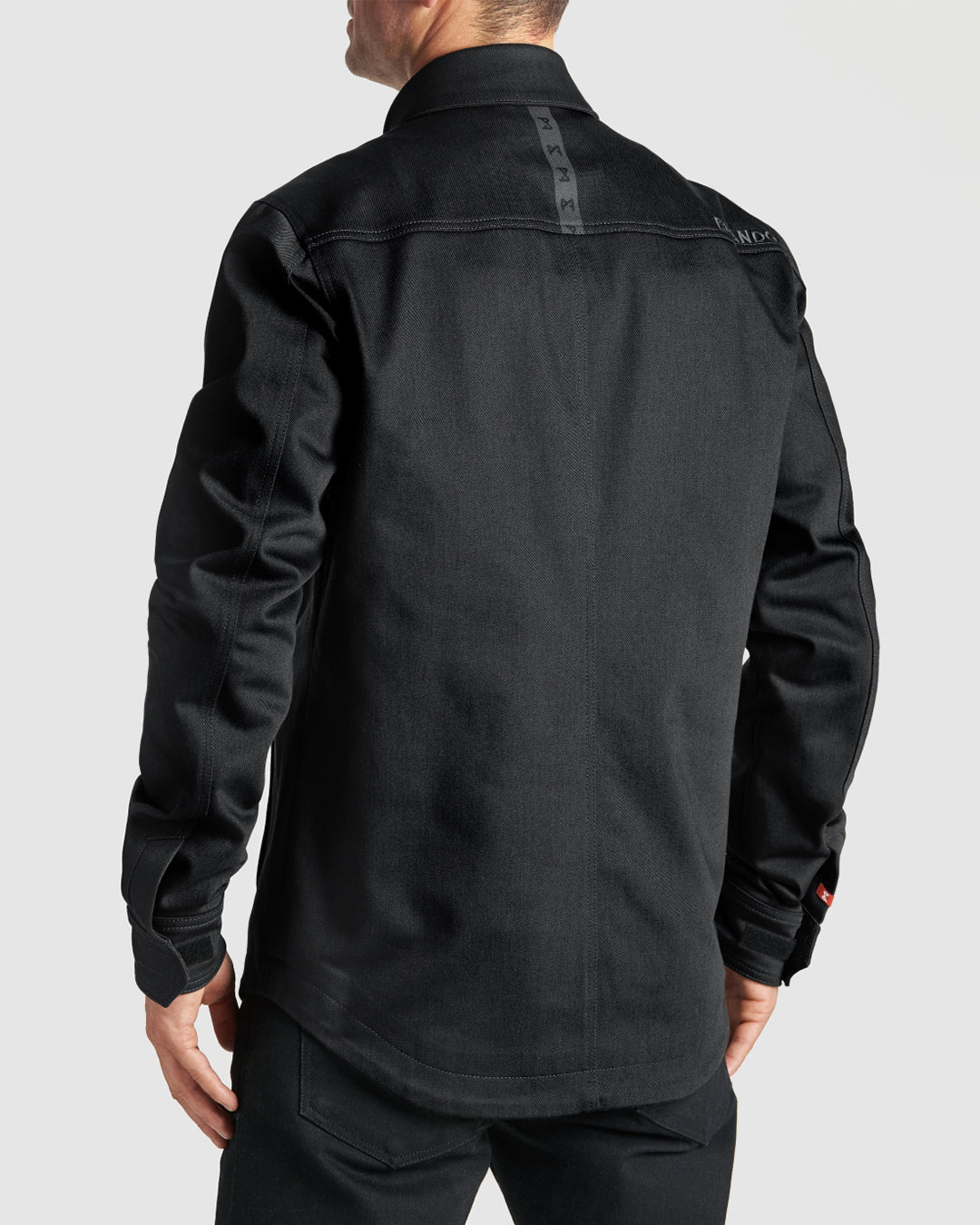 Back view of black Cordura® motorcycle overshirt featuring extended back panel, belt loop strap, and subtle reflective strip