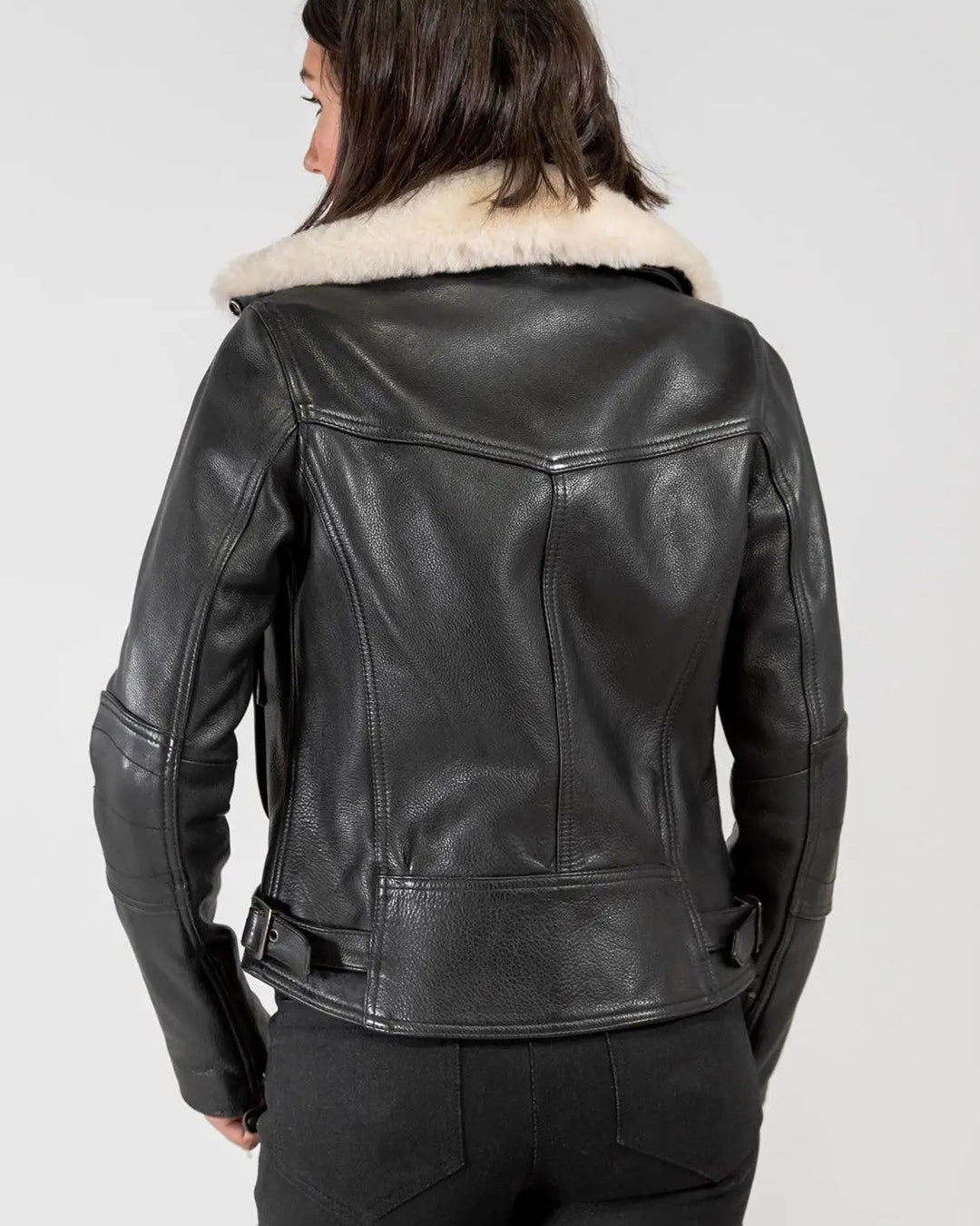 Rear view of woman wearing Merla Moto Fly By Night black leather jacket, CE approved armor in shoulders and elbows for protection