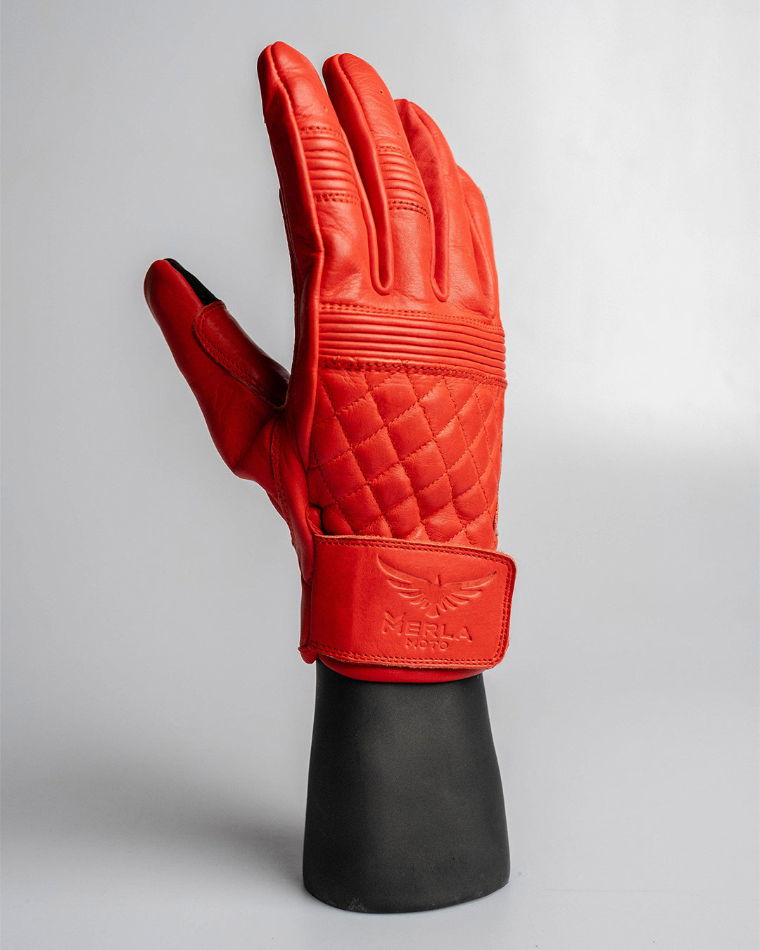 Top view of Merla Moto red leather motorcycle gloves with quilted upper panel, ribbed knuckle bands, and vintage styling